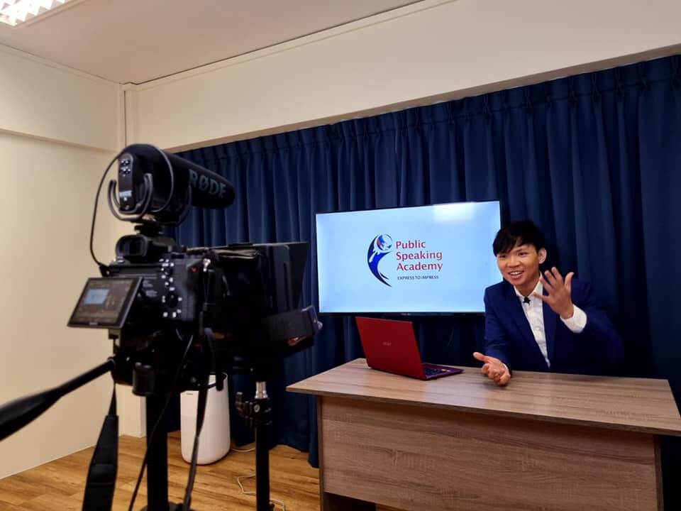 photo of 2016 public speaking world champion Darren Tay rehearsing his presentation in front of a camera